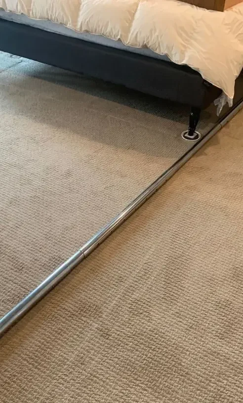 Smooth light beige bedroom carpet fully flattened and re-tensioned using a power stretcher tool.